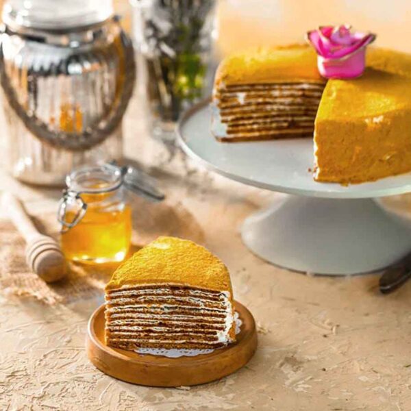 Layered honey cake slice with cream filling
